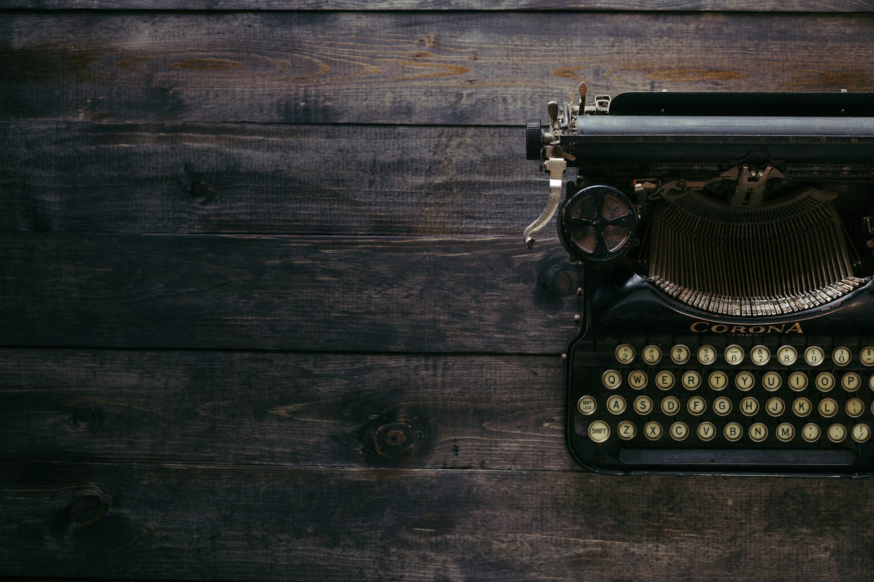 A vintage Corona typewriter on dark wooden planks